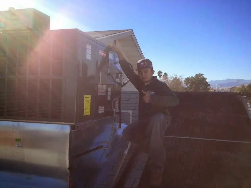 HVAC technician performing AC Tune-Up on a rooftop unit in Bristol